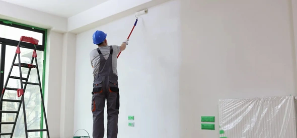 Residential painter painting a wall in a home for a refreshed interior.